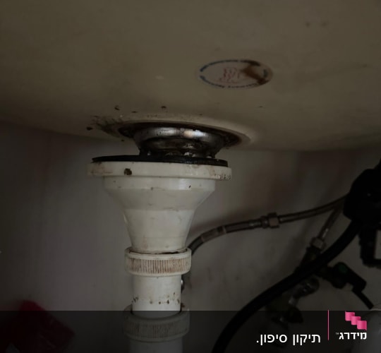 צנרת מתחת לכיור עם חיבורים וברזים